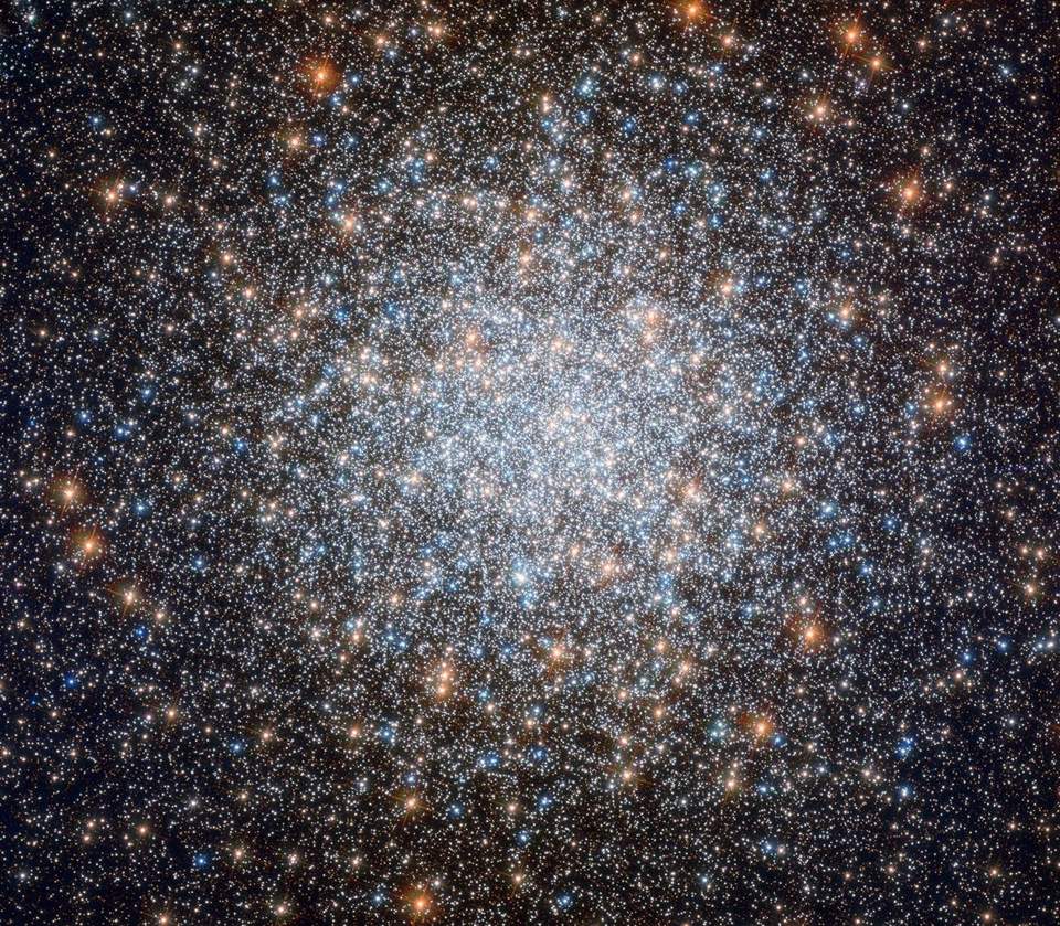 A sea of orange, yellow, blue, and white stars fills the image. The stars are concentrated at image center, becoming less so moving outward in all directions.